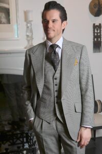 Cory in grey puppytooth suit with a waistcoat indoors